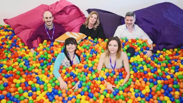 Empleados de Sleeping Giant Media en una piscina de pelotas de colores