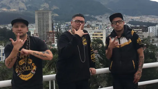 Três membros do grupo Latin Kings fazem gestos que representam seu grupo na universidade