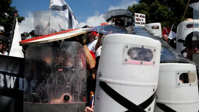 در این تصویر راست‌گرایان افراطی با سپر برابر مخالفان قرار گرفته‌اند و روی پلاکاردی نوشته‌اند: "رسانه‌های یهودی رو به افولند"