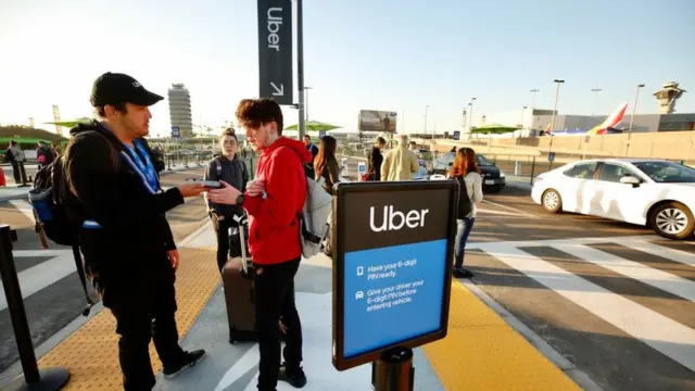 Passageiros esperando um veículo do Uber no aeroporto