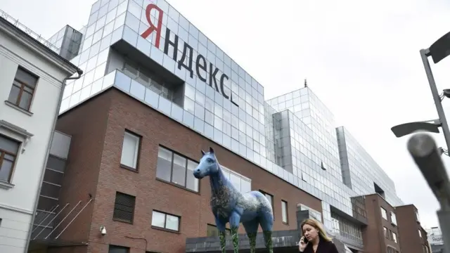 Женщина говорит по телефону возле главного офиса Яндекса в Москве, 16 мая 2017 года