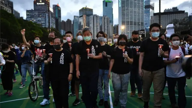 Protesters hold candlelit remembrance after crossing downed barricades into Victoria Park in Hong Kong on June 4, 2020