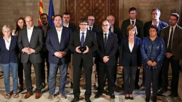 Lãnh đạo Catalonia Carles Puigdemont bên cạnh các thành viên trong chính phủ của ông khi đưa ra tuyên bố của mình.