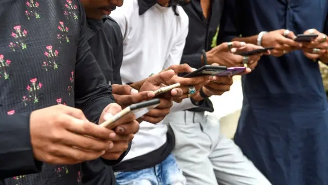 Homens indianos segurando telefones