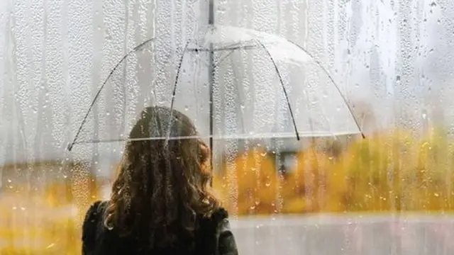 Pessoacaça niquel perfeitocostas segura guarda chuva transparentecaça niquel perfeitomeio à chuva