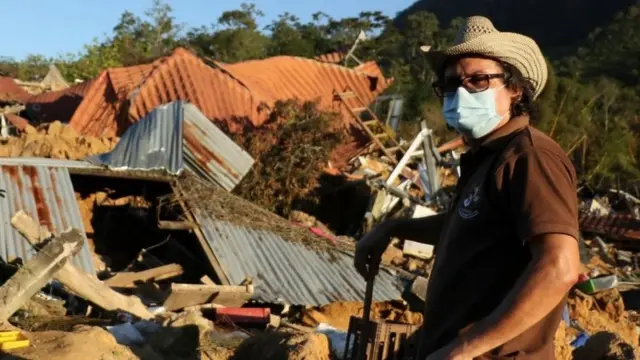 Persona frente a su casa destruida en Honduras.