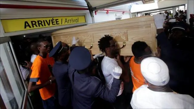 Abakinnyi ba Côte d'Ivoire barimo na Gervinho (wambaye umupira w'umweru) bateruye umurambo wa Tiote ugeze ku kibuga cy'indege cy'i Abidjan