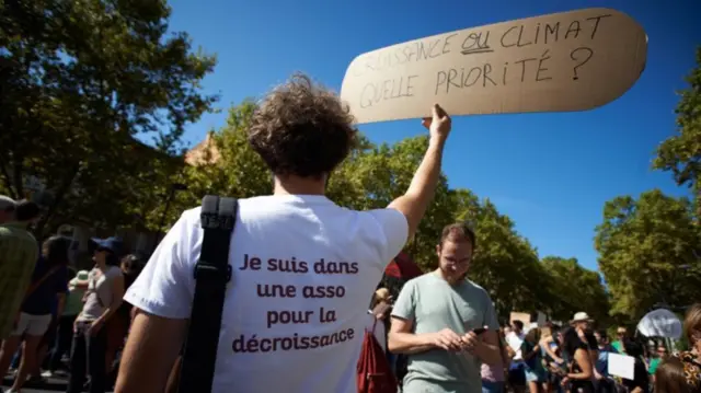 Manifestante protesta a favor do decrescimento na Françaqual o melhor aplicativo de aposta de jogo2018, com cartazqual o melhor aplicativo de aposta de jogoque se lê: ‘Crescimento ou clima, o que é prioridade?’