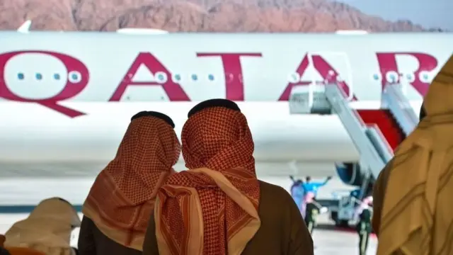 Foto archivo de dos mujeres viendo un avión de Qatar Airways