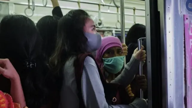 Para pekerja kantor naik kereta komuter.