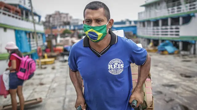 Homem usa máscara com a bandeira do Brasil