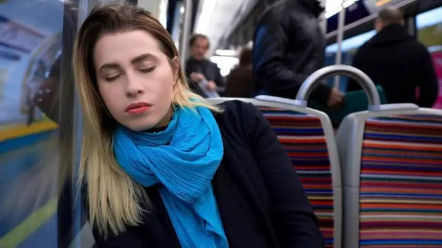 Una joven dormida en un tren del metro