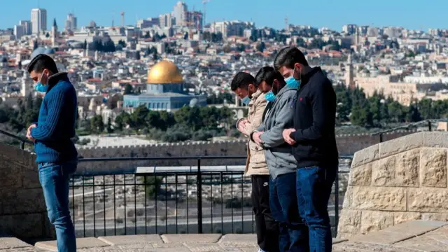 জেরুসালেমে আল-আকসার কাছে নামাজ পড়ছেন মাস্ক পরা কয়েকজন ফিলিস্তিনি