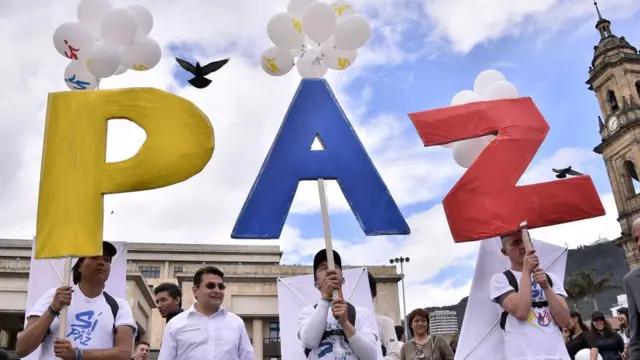 Manifestantes sostienen un cartel con la palabra Paz en Bogotá, Colombia.