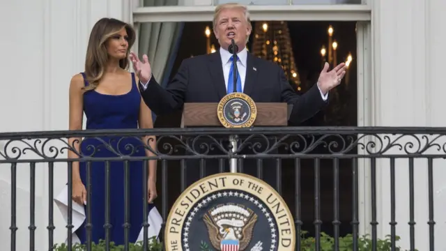 Donald Trump hablando en la Casa Blanca junto a Melania Trump.