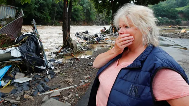 Uma mulher olha para os destroços trazidos pela enchente ao lado do rio Ahr