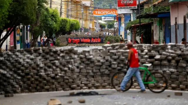 Manifestantes sostienen carteles de protesta.