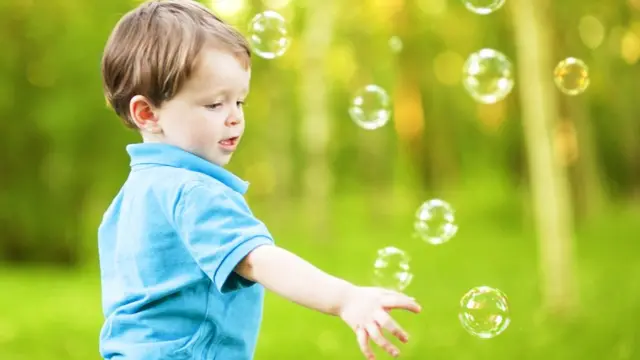 Niño persigue burbujas