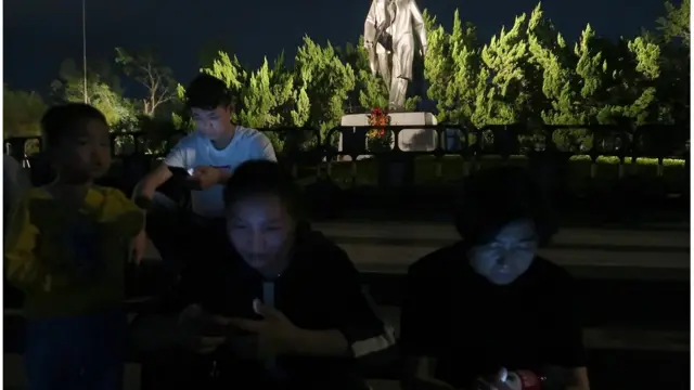 People sit on steps in front of the statue of the former Chinese leader Deng Xiaoping ahead of the 40th anniversary of China"s reform and opening up in Shenzhen, Guangdong province, China December 4, 2018. Picture taken December 4, 2018. REUTERS/Thomas Suen