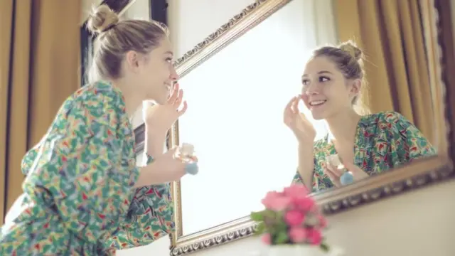 aynada krem süren kadın