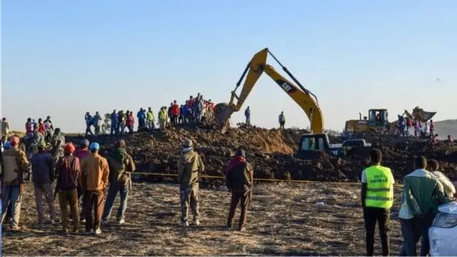 救援人员和挖掘机赶到坠机现场。