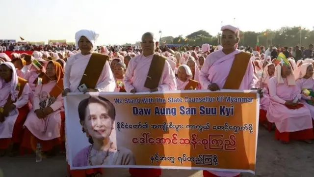 Myanmar Buddhist nuns hold a banner with the image of Myanmar State Counsellor Aung San Suu Kyi