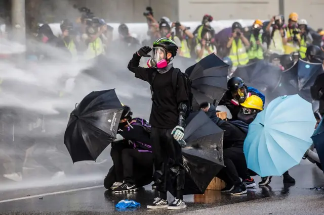 Wanaharakati wa kupigania demokrasia wakijikinga dhidi ya maji ya mwasho kutoka kwa magari polisi wa kizima ghasia Hong Kong mwezi Septemba 15, 2019.