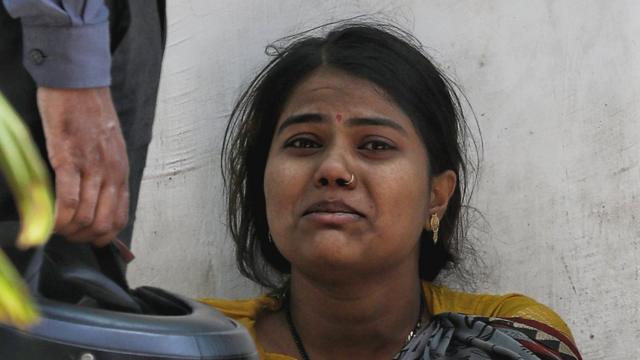 Uma mulher chorando do lado de fora de um crematório