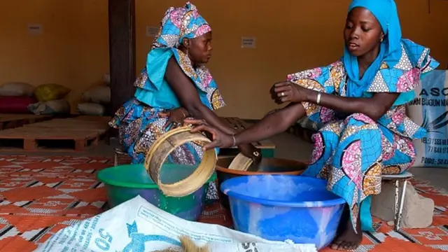 Girls wey dey sieve rice