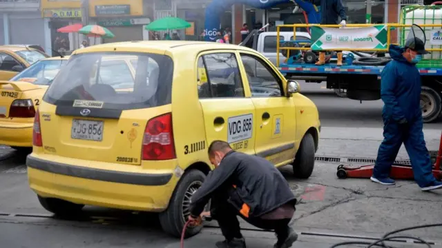 Taxista cambia llanta