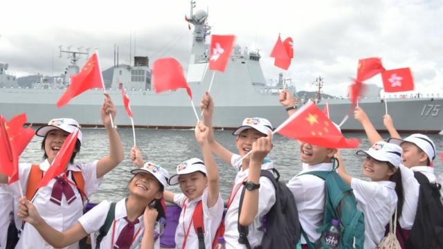 當局安排的學生代表在昂船洲海軍基地迎接遼寧艦編隊（中新社7/7/2017）