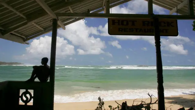 Una persona en una choza playera, en contraluz