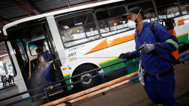 A health worker sprays disinfectant on railings to combat the spread of coronavirus disease (COVID-19) at a bus depot in Cape Town, South Africa, March 18, 2020