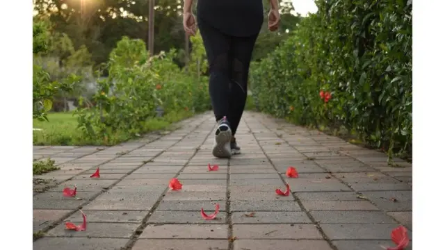 mujer caminando sobre pavimento rayado