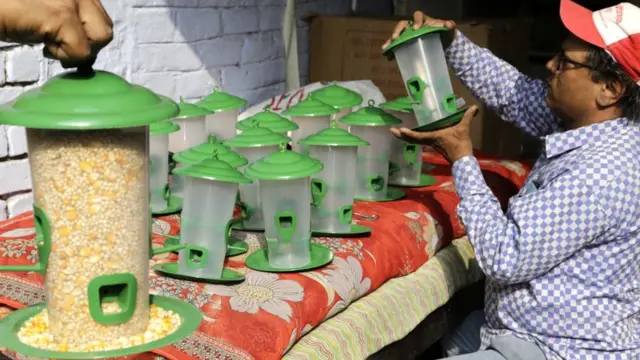 પક્ષીઓના ફીડર સાથે એક વ્યક્તિ