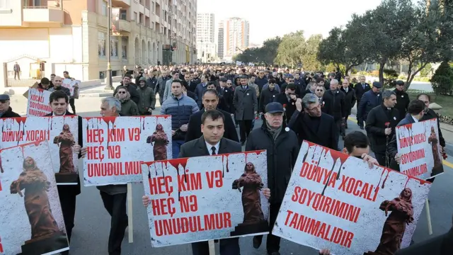 "Heç kim və heç nə unudulmur" plakatını tutan yürüş iştirakçıları