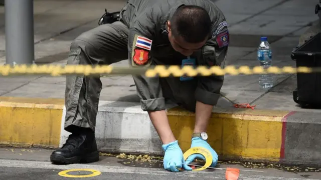 เจ้าหน้าที่เก็บพยานหลักฐานบริเวณ 1 ในจุดเกิดเหตุระเบิดในกรุงเทพฯ เมื่อ 2 ส.ค. 2562