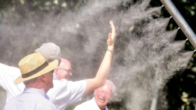Pessoas se refrescam em equipamentos que disparam água