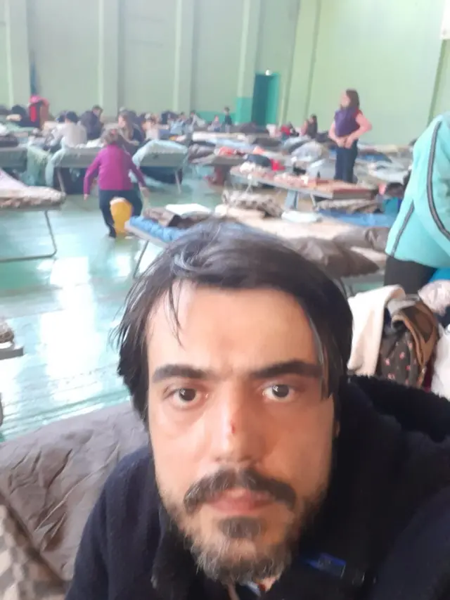 Devrim Çiner, Rusya'da güvenli bir yere geçiş sırasında ailesiyle konakladığı, savaştan kaçanların kaldığı bir spor salonunda.