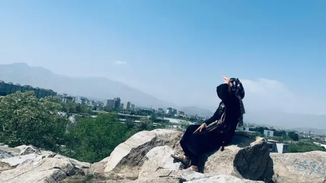 Avganistanka Nadia sedi u crnoj garderobi na stenama poviše grada