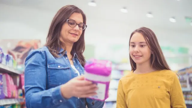 Mulher brancacasas de apostas com bônus de registro 2024óculos mostra absorvente para a filha, uma menina brancacasas de apostas com bônus de registro 2024cabelo comprido