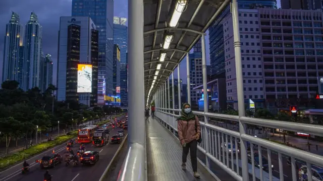 Mujer cruzando un puente en Yakarta