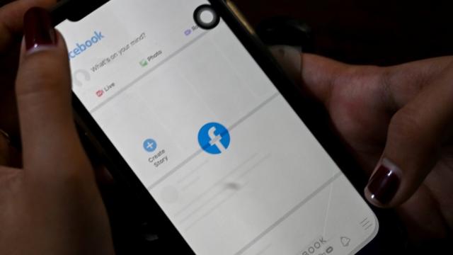 Uma mulher usa seu telefone celular para verificar o Facebookunibet livescoreYangonunibet livescore4unibet livescorefevereirounibet livescore2021