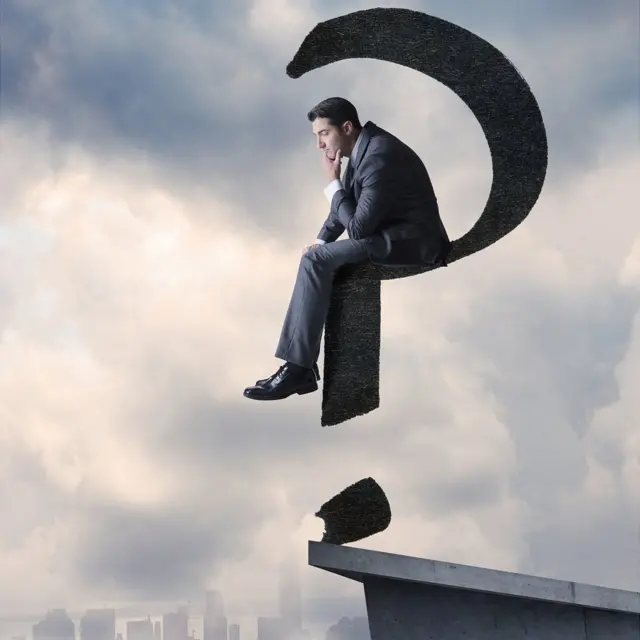 Homme assis sur un point d'interrogation