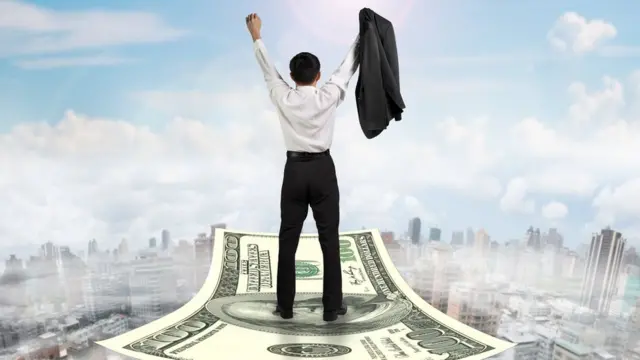 Una persona subida a un billete que hace las veces de "alfombra mágica"