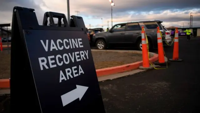 Парковка, где людей просят подождать после прививки и не отправляться сразу же домой на тот случай, если им станет плохо