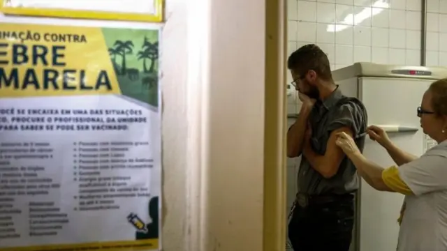 Une femme faisant une piqure au bras d'un homme