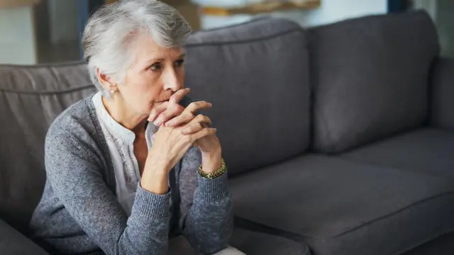 Mujer preocupada en sofá