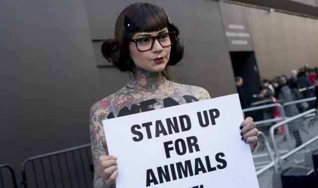 Активистка Peta с плакатом