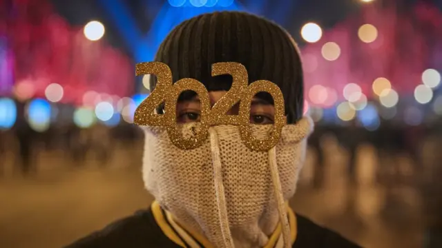 Una persona festeja la llegada de 2020 con lentes 2020.
